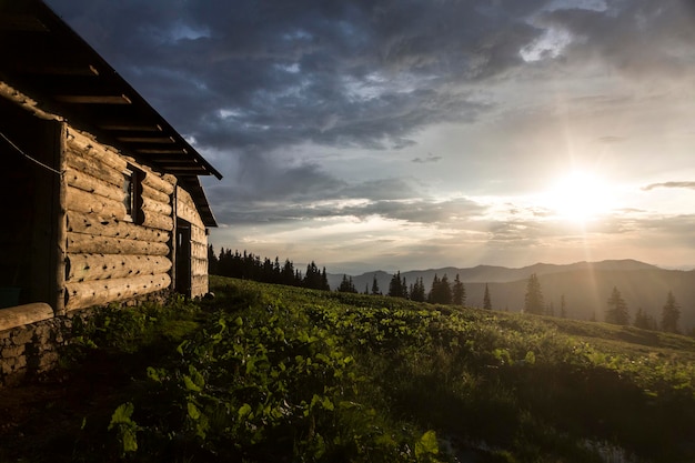 Abendsonnenstrahlen leuchten auf einem Holzhaus in den Bergen Karpaten Marmaroshchyna Maramures Ukraine