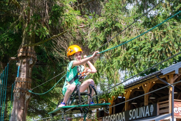 Foto abenteuerklettern hochseilpark leute auf kurs in berghelm und sicherheitsausrüstung