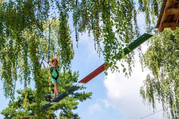 Abenteuerklettern Hochseilpark Leute auf Kurs in Berghelm und Sicherheitsausrüstung