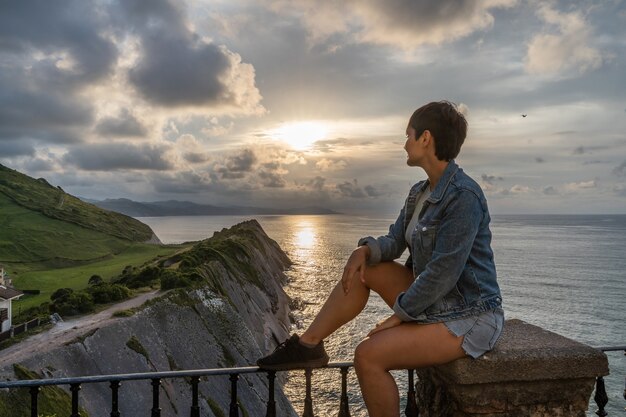 Abenteuerliche Reisende Frau Sightseeing in Zumaia Klippen Reiseziel. Horizontaler Panoramablick auf eine Frau, die im Vaskenland reist. Menschen und Reisen in Spanien-Konzept.