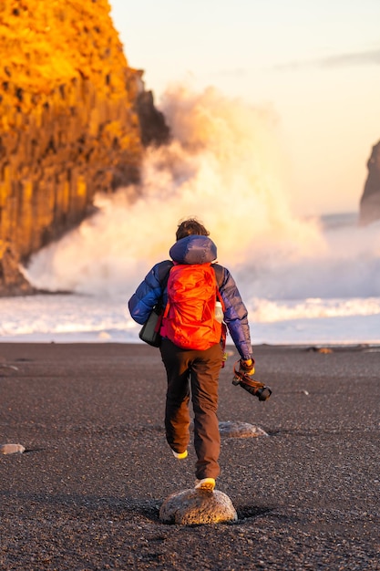 Abenteuerlustige Fotografin von hinten im Winter in Island auf dem Besuch des Reynisfjara Black Sand Beach