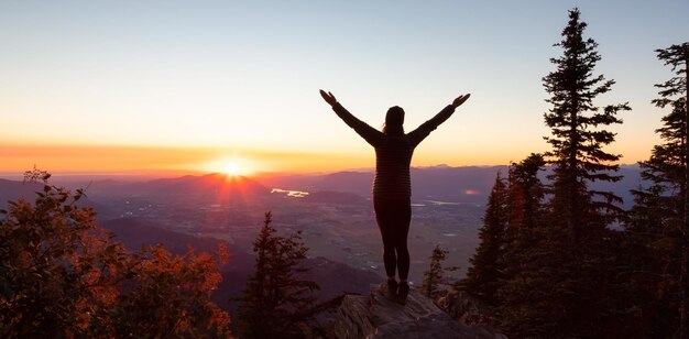 Abenteuerlustige Frau Wandert in der kanadischen Landschaft mit Herbstfarben bei sonnigem Sonnenuntergang Elk Mountain Chilliwack Östlich von Vancouver British Columbia Kanada Abenteuerreise-Konzept