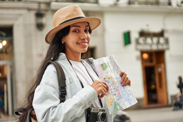 Foto abenteuerlustige latina-touristin erkundet neue stadt mit kamera