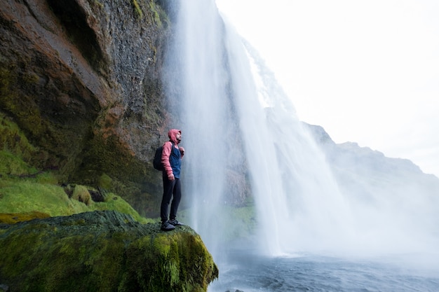Abenteuermann am Skogafoss-Wasserfall, Natur auf Island. Vatnajökull-Nationalpark. Junger Mann, der Naturlandschaft besucht.