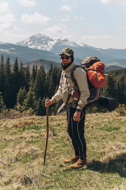 Abenteurer steht auf dem grünen Berghang