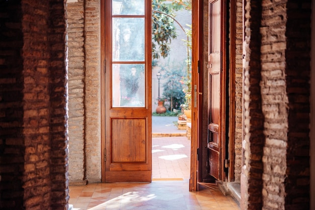 Abertura da porta para o pequeno e aconchegante jardim do pátio interno na itália