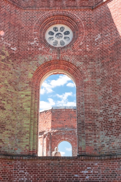 La abertura de la ventana está hecha de ladrillo rojo. Una ventana en un edificio en ruinas. Un agujero en el yeso.