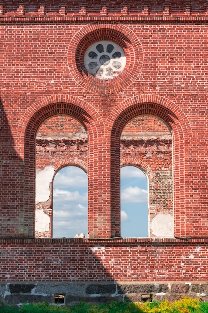 Aberturas de janela da antiga igreja católica em ruínas. A parede de tijolo vermelho da igreja antes do resto