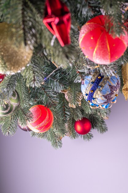 Abeto decorado para la celebración de Navidad o año nuevo con fondo gris neutro.