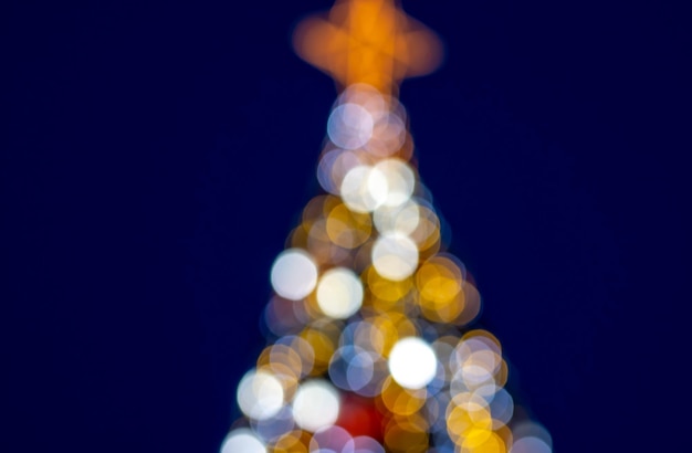 abeto desenfocado de luces bokeh árbol de Navidad de luz multicolor con forma de estrella en la parte superior