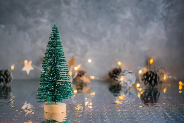 Abeto esponjoso decorativo de Navidad sobre un fondo gris con luces borrosas. Fondo de Navidad. Copia espacio
