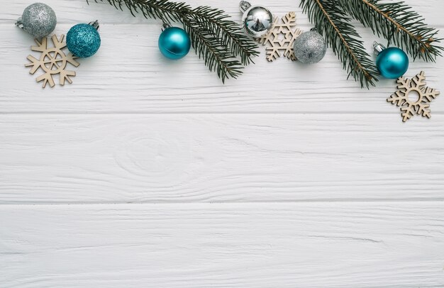 Abeto de Navidad con decoración y brillos sobre fondo de madera.