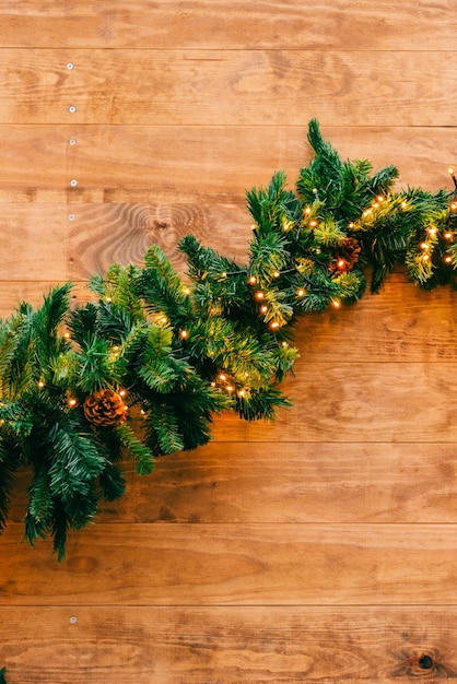 Abeto de Navidad con luces sobre fondo de madera con espacio de copia