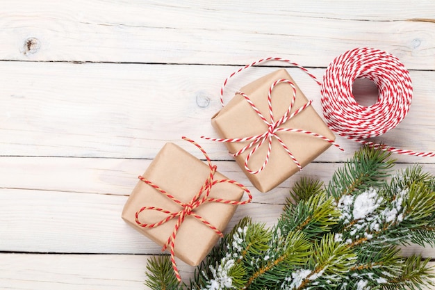 Abeto de navidad con nieve y cajas de regalo.