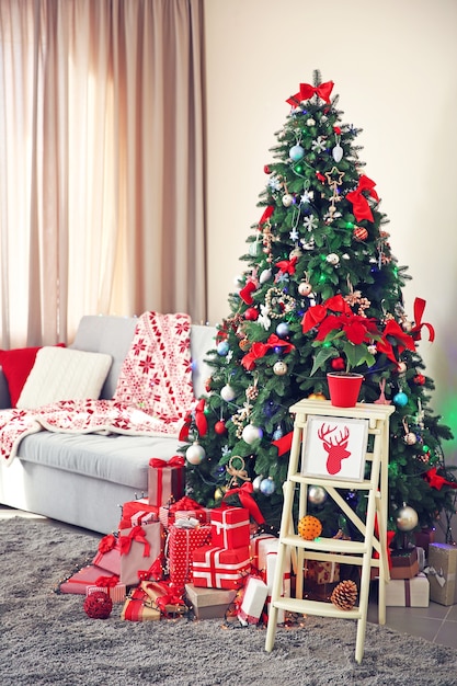 Abeto de Navidad con regalos en salón.