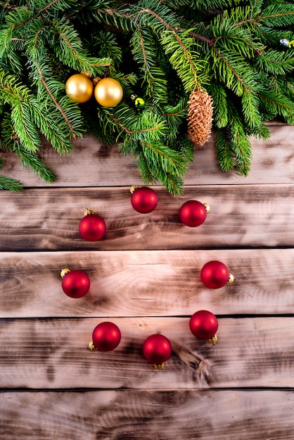 Abeto de Navidad sobre fondo de madera natural con bolas rojas.