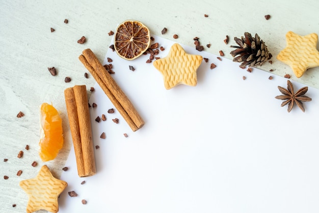 Abetos, galletas, canela y cintas de oro sobre fondo blanco. Marco reeting tarjeta de año nuevo. Concepto de vacaciones de navidad. Copia espacio, plano