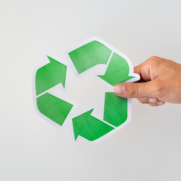 Abfallrecycling, Wiederverwendung, Müllentsorgung, Umwelt- und Ökologiekonzept - Nahaufnahme der Hand mit grünem Recycling-Symbol