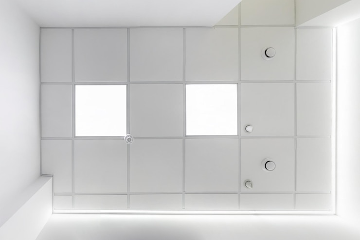 Foto abgehängte kassettendecke mit quadratischen halogenstrahlern und trockenbau in leerem raum in einem büro oder haus einer wohnungsklinik spanndecke weiß und komplexe form blick nach oben