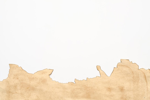 Abgeschnittene Aufnahme von beigefarbenem Pergamentpapier mit verbranntem Rand auf weißem Hintergrund Abstraktes Retro-Design Kopieren Sie Platz