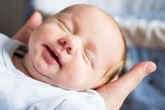 Abgeschnittene Hände einer Mutter, die ihre schlafende Tochter zu Hause hält