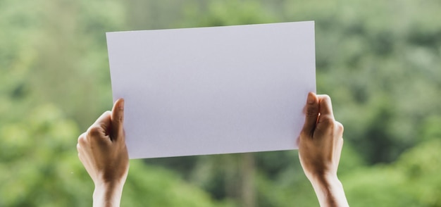 Foto abgeschnittene hände einer person, die ein leeres plakat hält