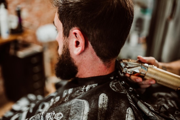 Foto abgeschnittene hände eines friseurs, der einen kunden im salon pflegt