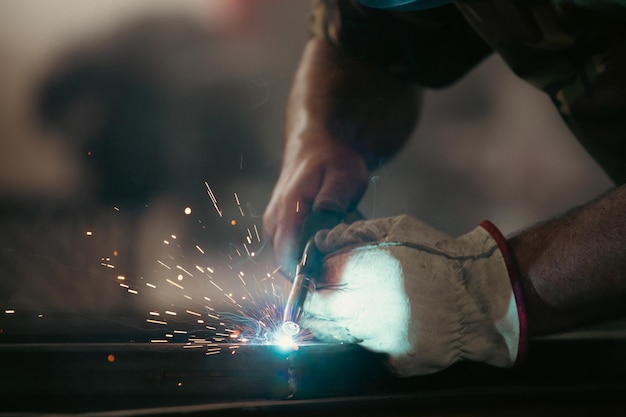 Abgeschnittene Hände eines Schweißers, der in der Fabrik arbeitet