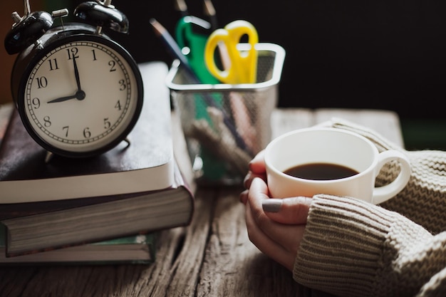 Foto abgeschnittene hände halten eine kaffeetasse auf dem tisch