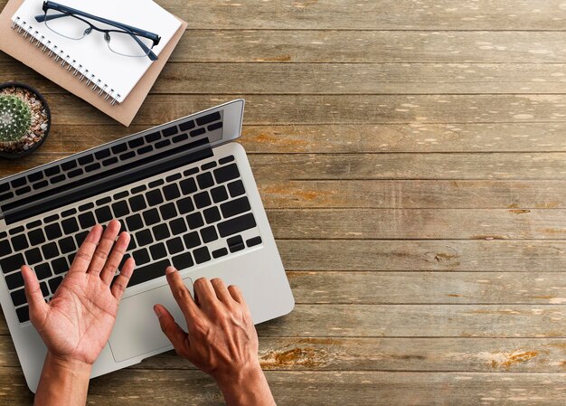 Foto abgeschnittene hände mit laptop am tisch