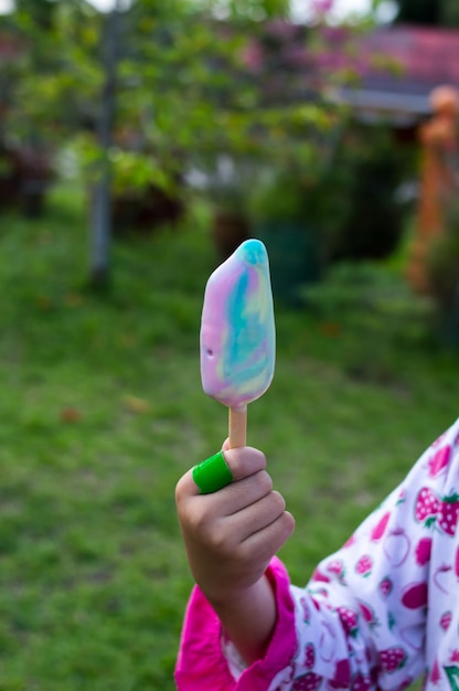 Foto abgeschnittene hand, die einen eiscreme-kegel hält