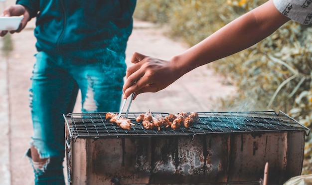 Abgeschnittene Hand, die Essen auf dem Grill zubereitet