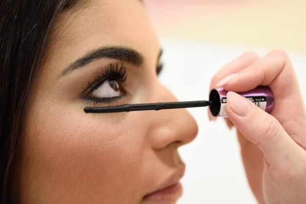 Foto abgeschnittene hand, die mascara aufträgt