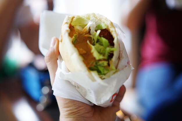 Foto abgeschnittene hand, die shawarma hält