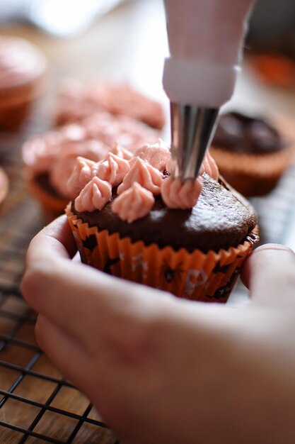 Abgeschnittene Hand einer Frau, die Dessert hält.