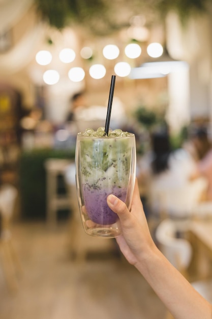Abgeschnittene Hand einer Frau, die ein Getränk im Restaurant hält