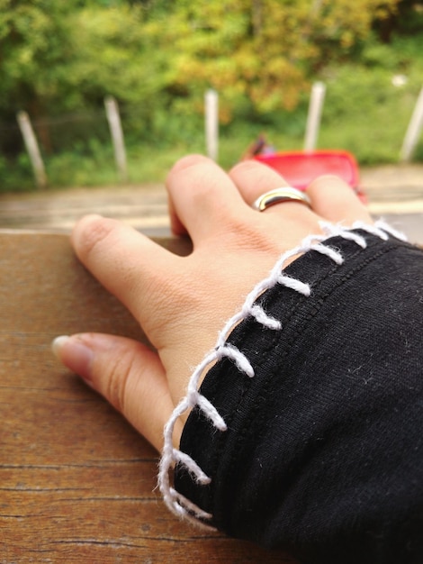 Foto abgeschnittene hand einer frau, die einen ehering am fenster trägt