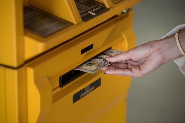 Foto abgeschnittene hand einer frau, die einen geldautomaten benutzt