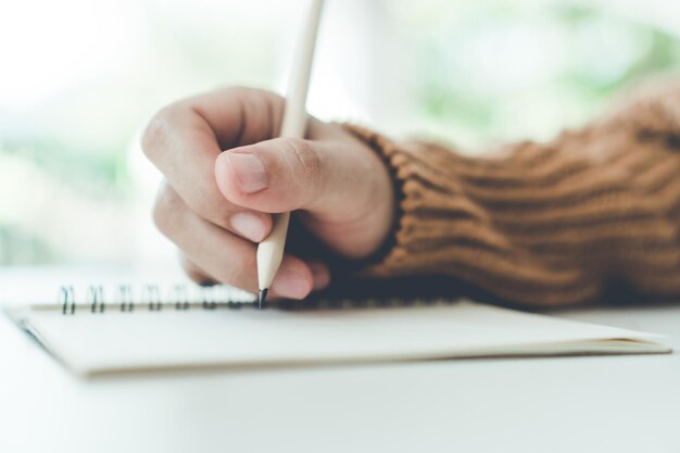 Foto abgeschnittene hand einer frau, die tagebuch schreibt