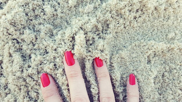 Foto abgeschnittene hand einer frau im sand