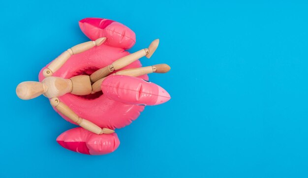 Abgeschnittene Hand einer Frau mit Ballons auf blauem Hintergrund