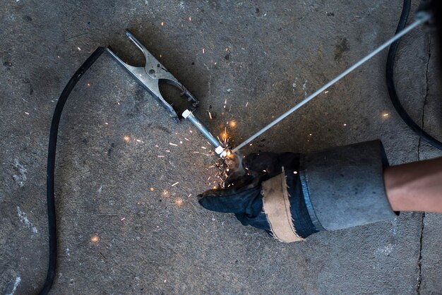 Foto abgeschnittene hand einer person, die an metall arbeitet