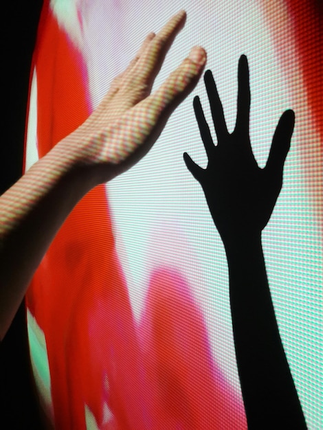 Abgeschnittene Hand einer Person mit Schatten auf dem Projektor