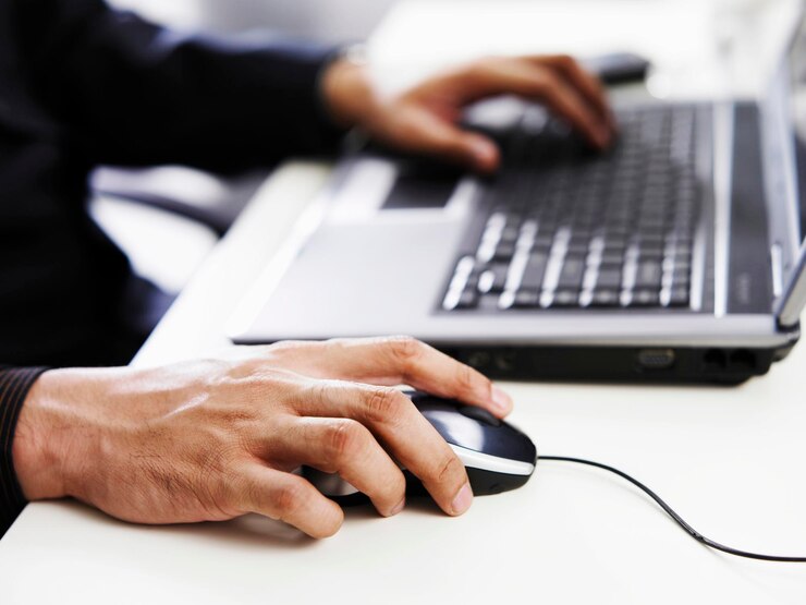 Foto abgeschnittene hand eines geschäftsmannes mit laptop auf dem tisch