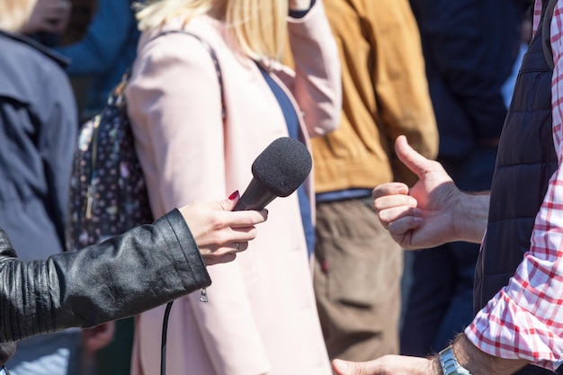 Foto abgeschnittene hand eines journalisten, der im freien ein interview führt