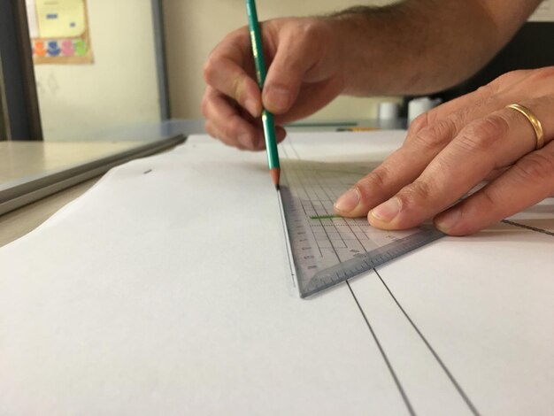 Foto abgeschnittene hand eines mannes, der auf papier zeichnet