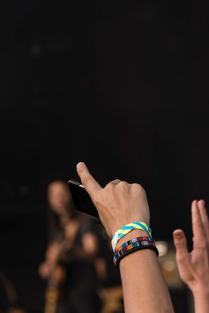 Foto abgeschnittene hand eines mannes, der ein armband trägt und im freien ein smartphone hält