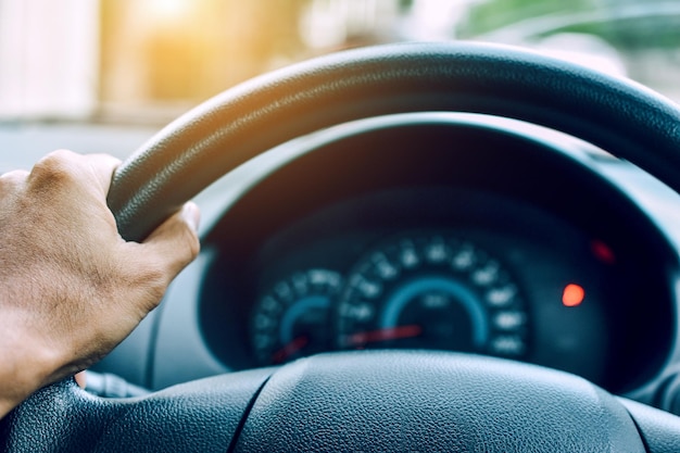 Abgeschnittene Hand eines Mannes, der ein Auto fährt