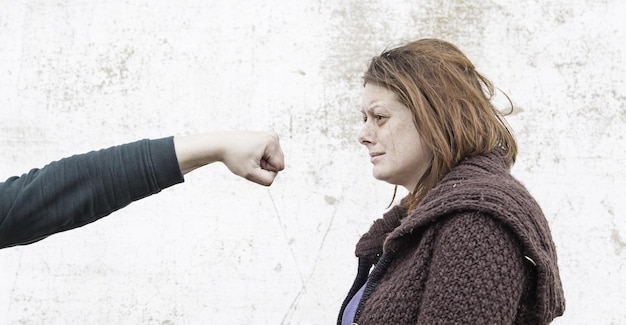 Foto abgeschnittene hand eines mannes, der eine frau an die wand schlägt