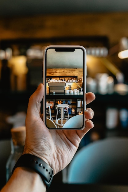 Abgeschnittene Hand eines Mannes, der mit einem Mobiltelefon fotografiert